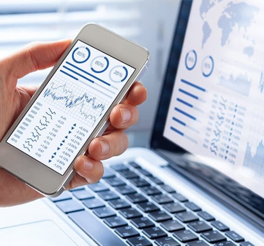 Telemóvel e computador a mostrar uma aplicação de business intelligence e analytics.