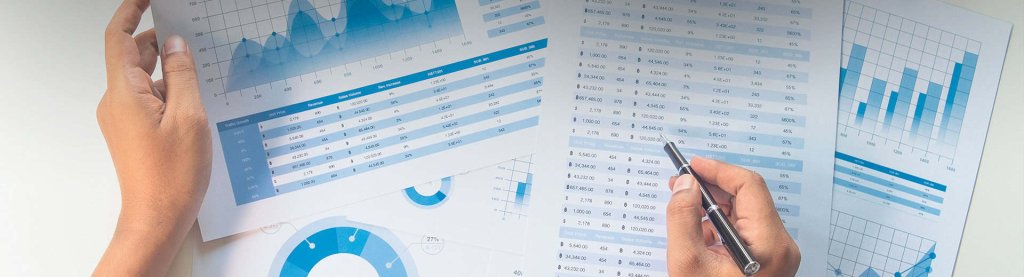 Utilizador de negócio a analisar relatórios impressos e digitais.